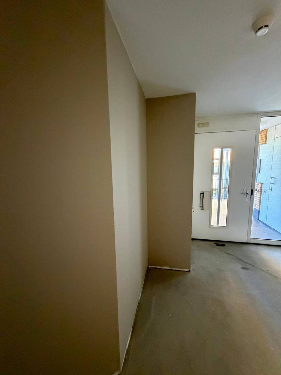 Entree van een appartement met egaal geschilderde wanden