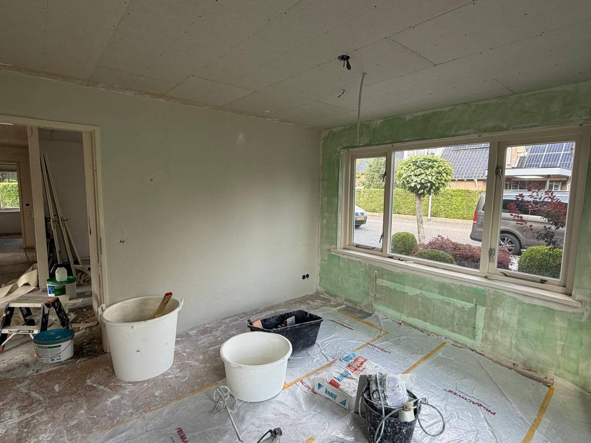 Kamer tijdens het stucwerk: wand gestuct, voorstrijk op de buitenmuur