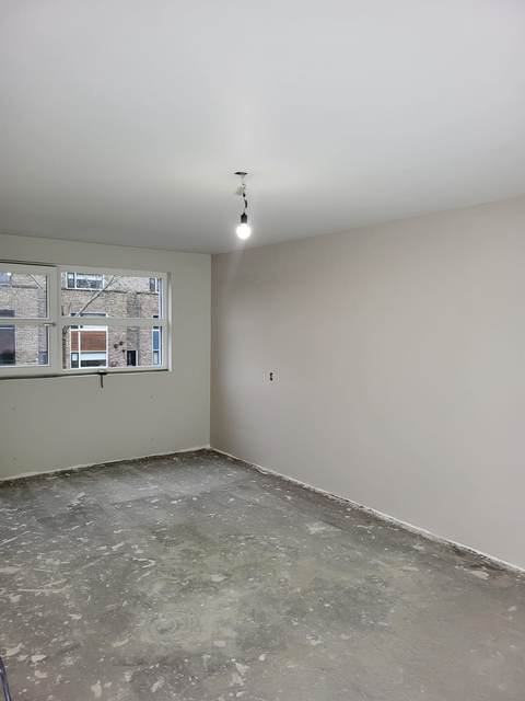 Kamer met wanden in een warme grijstint en een wit plafond