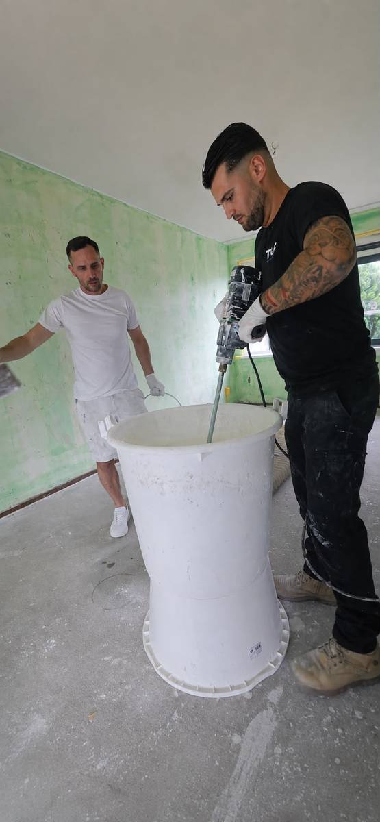 Twee vakmensen maken stucmortel aan in een kamer met voorstrijk