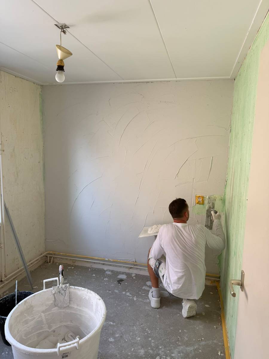 Stukadoor zet de stuclaag op een wand