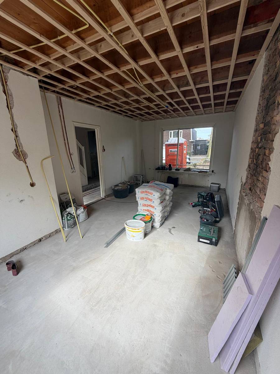 Woonkamer tijdens de renovatie, nieuw regelwerk tegen het plafond en stucmateriaal klaar